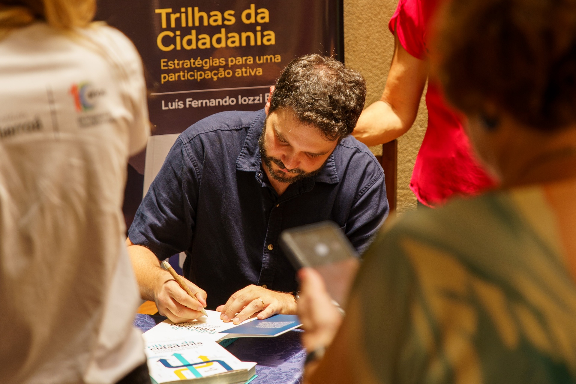 Autor autografando exemplares de Trilhas da Cidadania